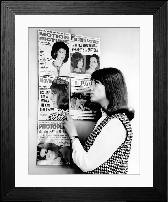 Framed Print : A young women observes a display of celebrity gossip magazine covers featuring widowed First Lady Jacqueline Kennedy and the often married actress Elizabeth Taylor. Mar. 28, 1965