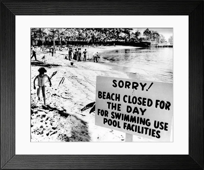 Framed Print : Puerto Rican Hilton Hotel beach closed by an oil spill. Workers in the background spray chemicals to clear the beach of crude oil leaking from a wrecked tanker offshore Framed Print : Puerto Rican Hilton Hotel beach closed by an oil spill. Workers in the background spray chemicals to clear the beach of crude oil leaking from a wrecked tanker offshore