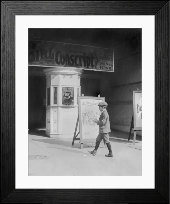 Framed Print : Boy in front of a movie theater showing THE GIRL CONSCRIPT, original caption reads: Where some of the newsboy's money goes, Wilmington, Delaware Framed Print : Boy in front of a movie theater showing THE GIRL CONSCRIPT, original caption reads: Where some of the newsboy's money goes, Wilmington, Delaware