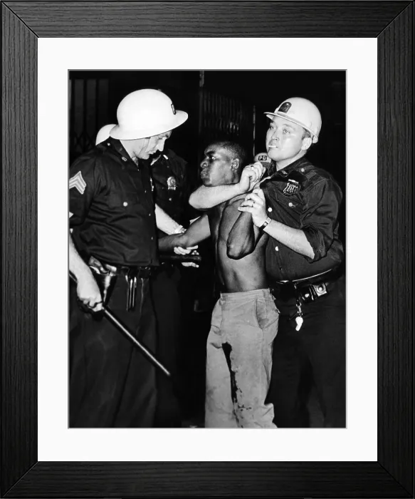 Framed Print : African American who has been shot in the leg, is restrained by New York City Police. He allegedly threw beer bottles at police on Lenox Avenue between 126 and 127th streets