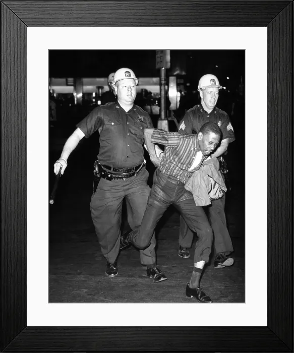 Framed Print : An African American who police accused of wielding a knife is taken into police custody. It was the fourth night of rioting on Harlem's 125th Street, July 21, 1964 Framed Print : An African American who police accused of wielding a knife is taken into police custody. It was the fourth night of rioting on Harlem's 125th Street, July 21, 1964