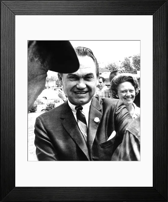 Framed Print : Lurleen Wallace a surrogate candidate for her husband, stays in the background as her husband, Governor George Wallace, shakes hands with voters in Clayton, Alabama. May 3, 1966