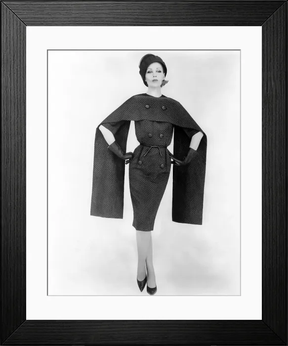 Framed Print : Dramatic checked dress and cape. Dress has double rows of large buttons to which is attached a long rectangular cape of the same fabric Framed Print : Dramatic checked dress and cape. Dress has double rows of large buttons to which is attached a long rectangular cape of the same fabric