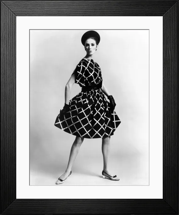 Framed Print : Dress by Pauline Trigere. Short and full skirted dress with a loose draped bodice. The model wears low heeled shoes that replaced the stilettos of the late 1950s and early 1960s