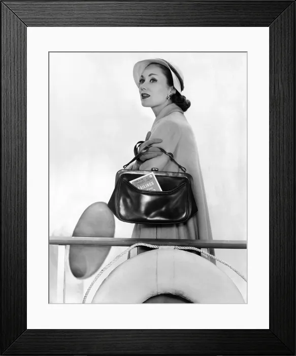 Framed Print : Travel Calf Bag. The top opening framed handbag with an outside pocket for easy access to travel documents. The model wears a full coat and tailored hat