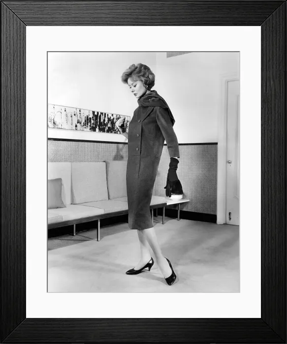 Framed Print : Below-the-knee trapezoid dress, also called the sack dress'. The sacks lasted only a short time before, and the waist returned until the mid-1960s. July 1958