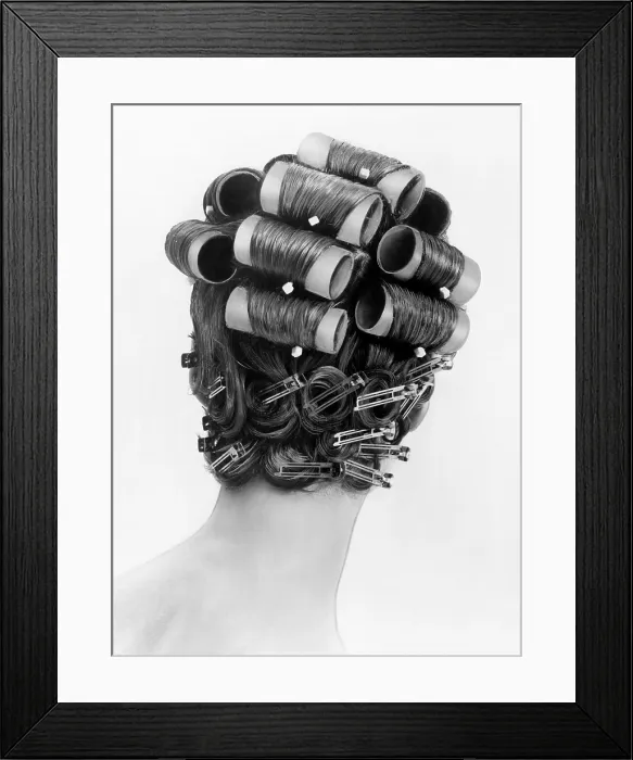 Framed Print : 1960s bouffant hair styles were created with big rollers on top of the head and pin curls to create a soft flip up at the neck. Back view. June 25, 1962