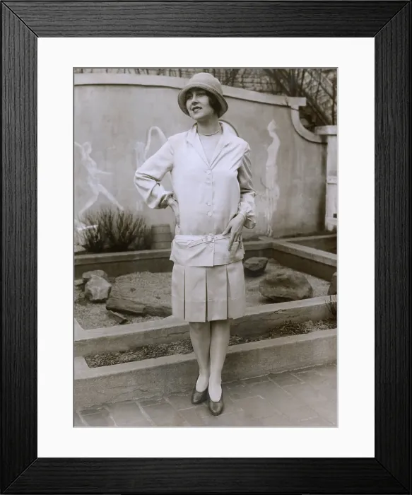 Framed Print : 1927 suit with a mid-knee pleated skirt and matching waistless, hip-belted jacket. The outfit is toped by a cloche hat. March 1927 Framed Print : 1927 suit with a mid-knee pleated skirt and matching waistless, hip-belted jacket. The outfit is toped by a cloche hat. March 1927