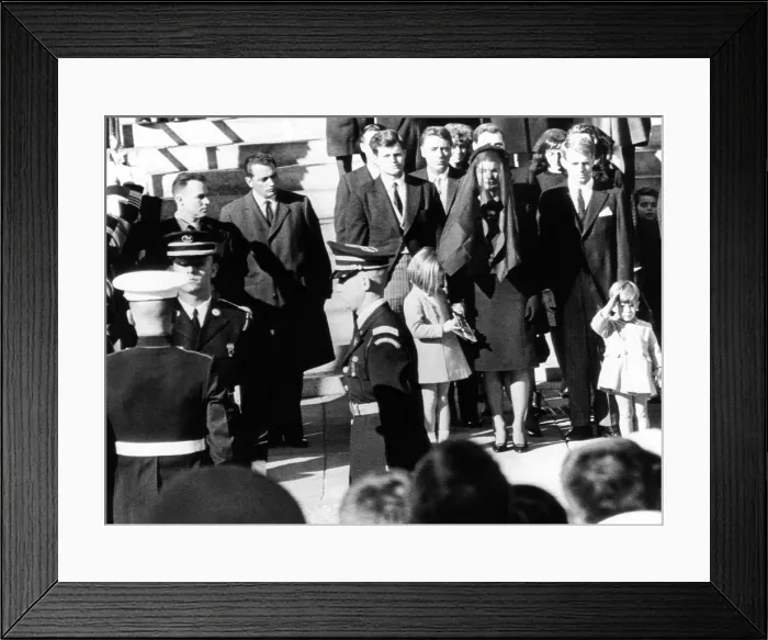 Framed Print : Three year old John F. Kennedy Jr. salutes his father's flag draped coffin after funeral mass at St. Matthew's Cathedral. Family members from center, L_R: Sen