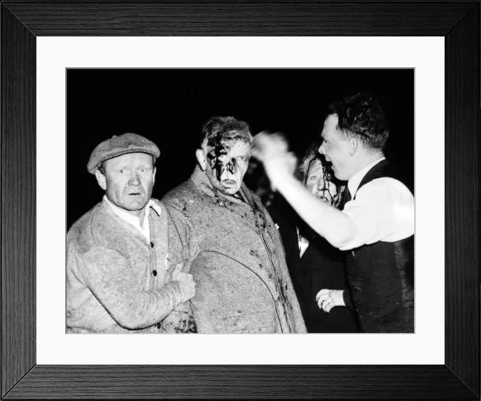 Framed Print : Injured in the Hindenburg Crash. Survivors are dazed and bloodied by the explosion, fire and crash, a man and women passenger are given first aid before going to the hospital