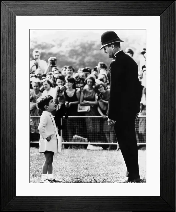 Framed Print : John F. Kennedy Jr. looks up at a British policeman during dedication ceremonies of a memorial to the late President Kennedy, at Runnymede, England. May 14, 1965 Framed Print : John F. Kennedy Jr. looks up at a British policeman during dedication ceremonies of a memorial to the late President Kennedy, at Runnymede, England. May 14, 1965