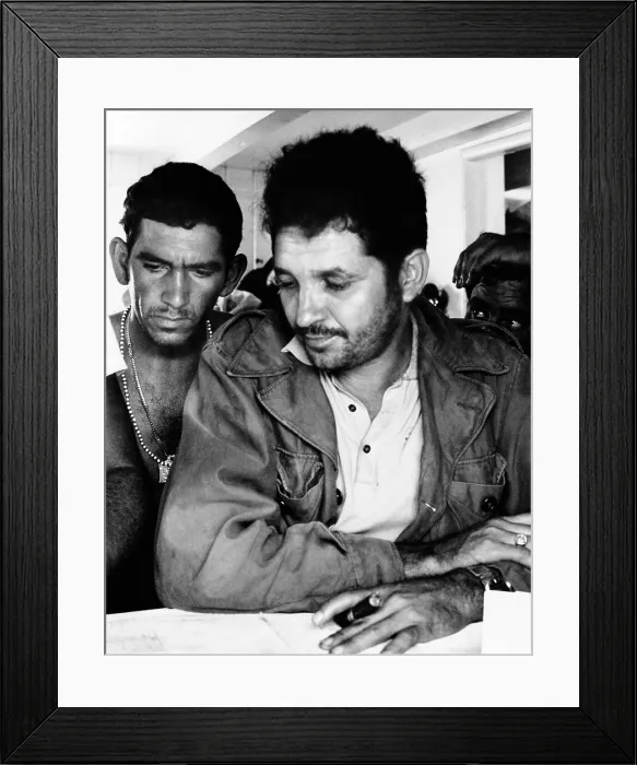 Framed Print : Col. Vincente Mendez views a map of his landing area