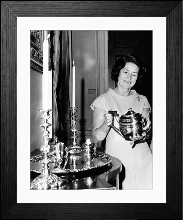 Framed Print : Lady Bird Johnson holds a silver teapot made by Issac Hutton. Made in New York City, the three piece set was donated to the White House by Mrs. Oscar Cox. Nov