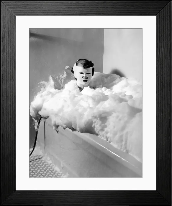 Framed Print : Helena Rubenstein Fifth Avenue Salon. Client in a bath of milk treated with compressed air to provide bubbles. The mask is a special device for restoring youthful contours