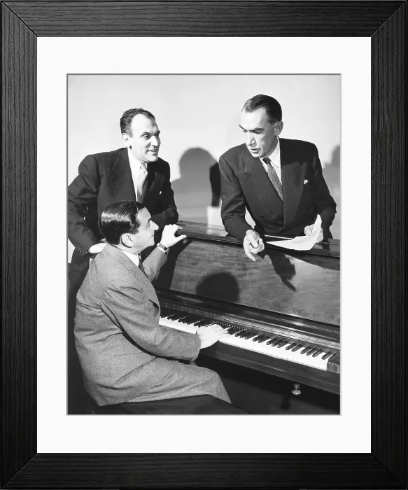 Framed Print : Moss Hart (left), Robert E. Sherwood, and Irving Berlin at the piano. They are collaborating on a new musical, Miss Liberty based on a book by Robert E