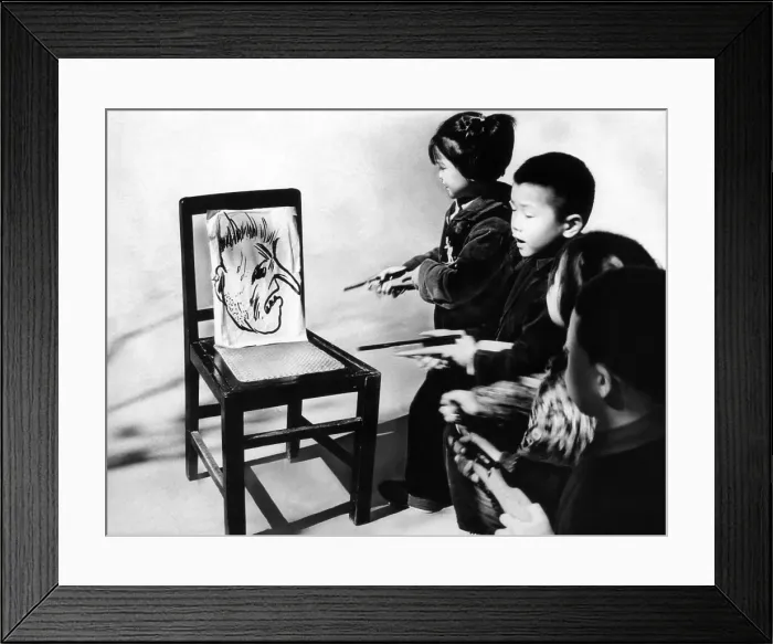Framed Print : Chinese youngsters aim toy pistols at the big nosed caricature of President Lyndon Johnson. Anti-American activities are part of elementary school lessons in Changchow, China