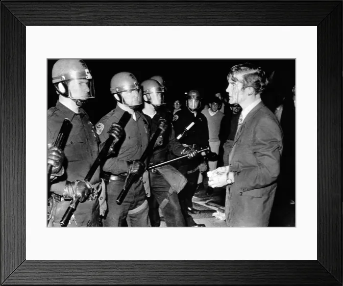 Framed Print : Terence Hallinan, an activist attorney, bloody from a gash in his head, confronts the police officer who clubbed him