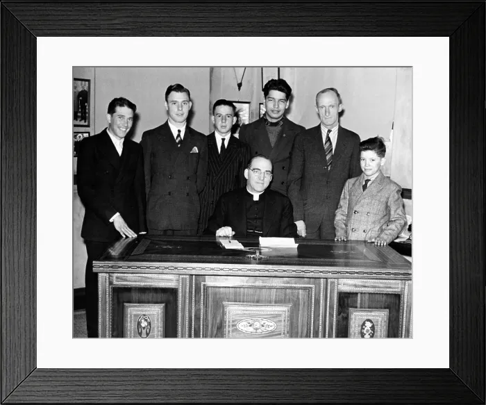 Framed Print : Father Edward Flanagan proudly sits on his desk made by Boys Town citizens over a period of three years Framed Print : Father Edward Flanagan proudly sits on his desk made by Boys Town citizens over a period of three years