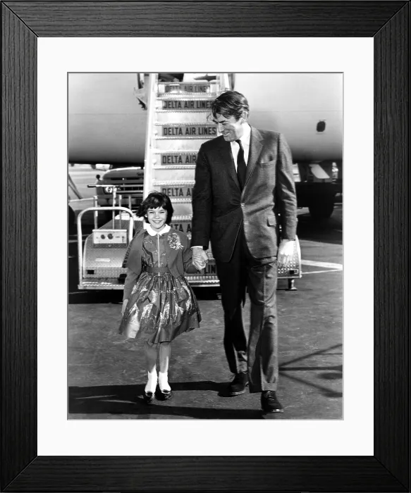 Framed Print : TO KILL A MOCKINGBIRD, Gregory Peck greets his on screen daughter, Mary Badham at the airport in Hollywood, 1962