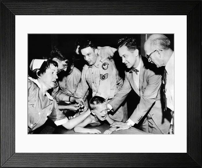 Framed Print : Several doctors and nurses restrain young Ernest Booth. Booth was one of 30, 000 children receiving gamma globulin inoculations during polio epidemic in Houston, Texas