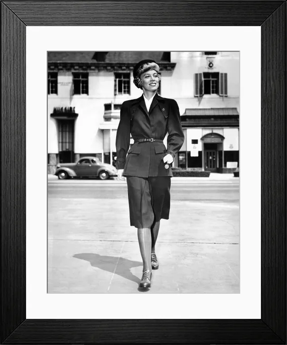 Framed Print : Wartime suit for women in defense work by Hollywood designer Irene Lentz. The suit is made of olive drab wool, with dyed cotton stockings to match. Sept. 1, 1942
