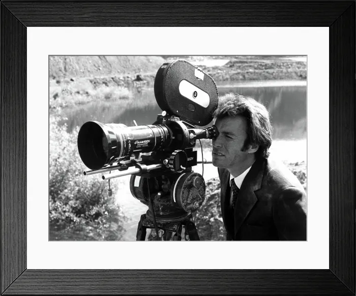 Framed Print : Star CLINT EASTWOOD checks a camera set up during production of DIRTY HARRY, 1971