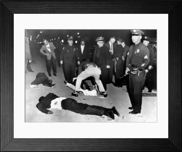 Framed Print : Black Muslims battle with Los Angeles Police. An officer keeps his shotgun at the ready as paramedics tend to Black Muslim shooting victims, one of whom will die