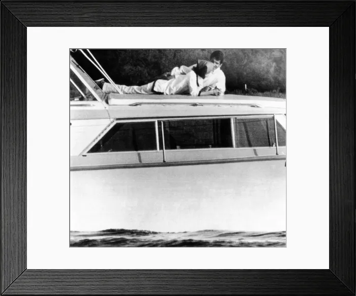 Framed Print : Lynda Bird Johnson relaxes on her father's cabin cruiser with her weekend guest, actor George Hamilton