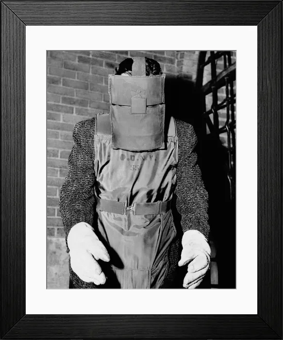 Framed Print : New York Police bomb squad working clothes. A policeman wears a steel shield over the face and a flack-proof suit. He sees through narrow slits in the mask. 1957 Framed Print : New York Police bomb squad working clothes. A policeman wears a steel shield over the face and a flack-proof suit. He sees through narrow slits in the mask. 1957