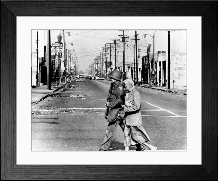 Framed Print : Peace in the midst of Riot. A National Guardsman escorts an elderly African American woman resident of the riot area across fire and violence-scarred street of Watts. Aug