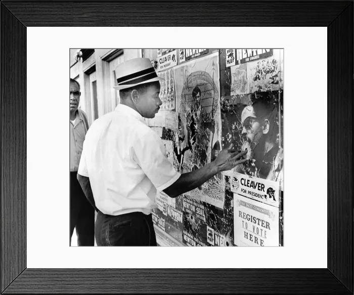 Framed Print : An African American pokes his finger into a bullet hole in the Oakland Black Panther's headquarters Framed Print : An African American pokes his finger into a bullet hole in the Oakland Black Panther's headquarters