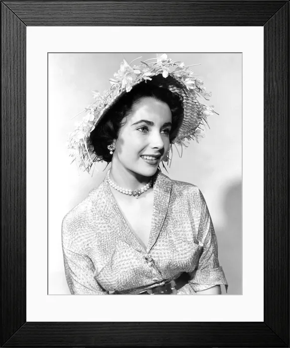 Framed Print : Elizabeth Taylor, modeling a straw hat trimmed with light-blue sweet peas, by Mr. John, 1952