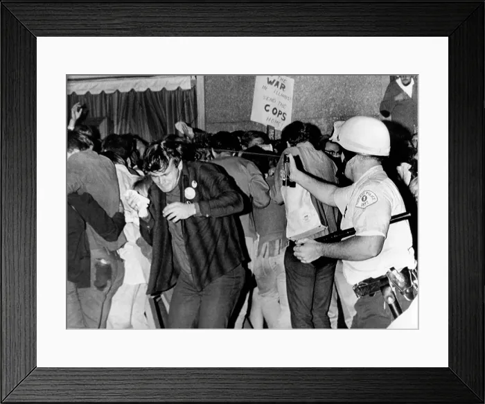 Framed Print : Chicago Police officer (right) uses pressure can to squirts mace at anti-Vietnam War demonstrators