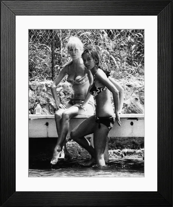 Framed Print : Brigitte Bardot and her companion glare at an invasive paparazzi, July 23, 1965. The privacy of her waterside villa could be broken by approaches from the water