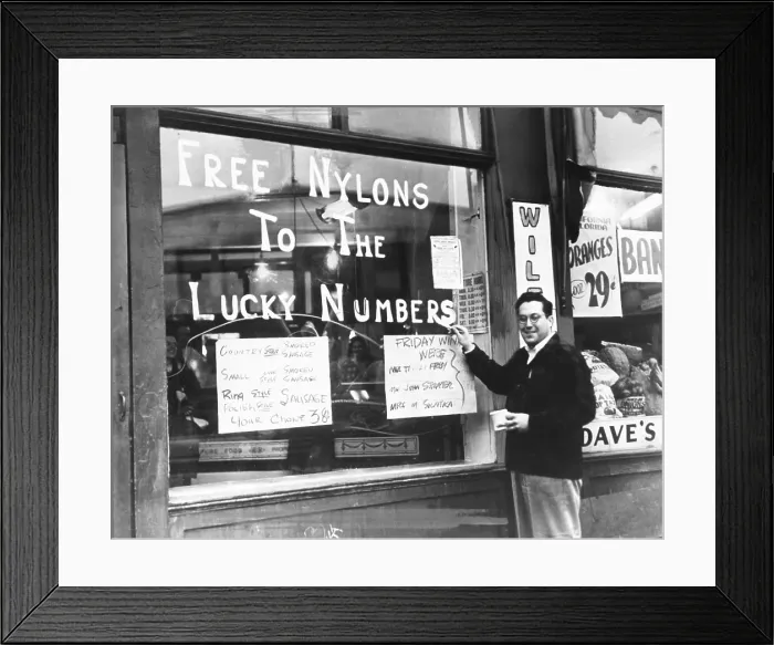 Framed Print : Cleveland grocer Max Astor promoting his grocery store with Free Nylons to the Lucky Numbers'. Nov. 5, 1946. He posts his meat specials, all of which are sausage
