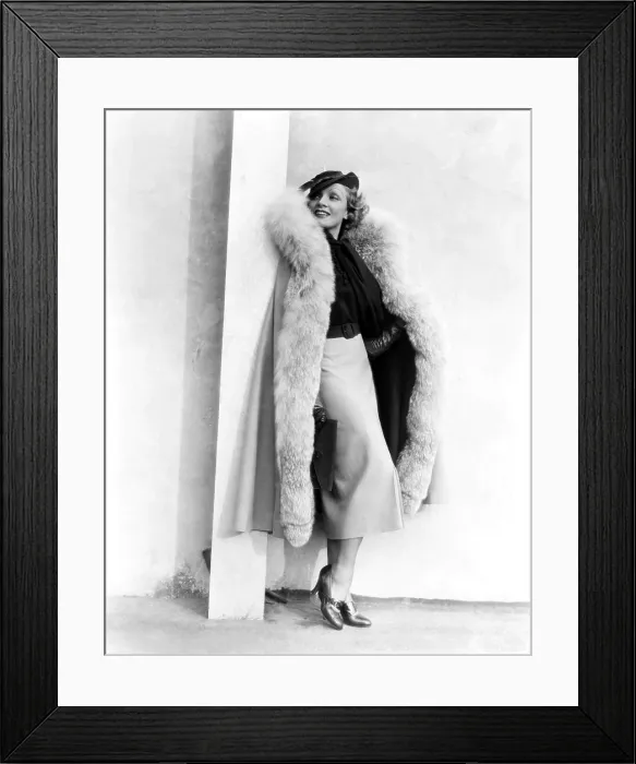 Framed Print : Marlene Dietrich, in a brown and beige suit and lynx-trimmed beige wool cape by Travis Banton, 1935
