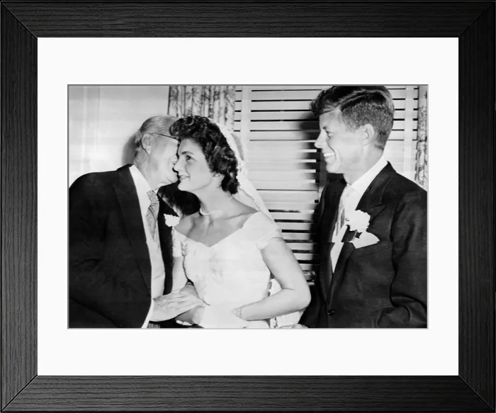 Framed Print : Joseph P. Kennedy kisses his new daughter-in-law, the former Jacqueline Lee Bouvier. The groom, his son, Senator John Kennedy is at right. Sept. 12, 1953