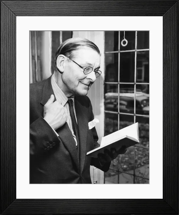 Framed Print : T.S. Eliot, smiling in reminiscence, Nov. 10, 1959. He is holding a book containing some of his early works during a press conference at the University of Chicago