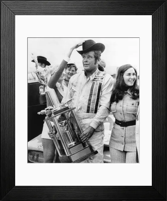 Framed Print : NASCAR racecar driver Buddy Baker after winning the Texas 500, Nov. 12, 1973. His average speed was 147.059 miles per hour. With him in victory circle is his wife, Coline