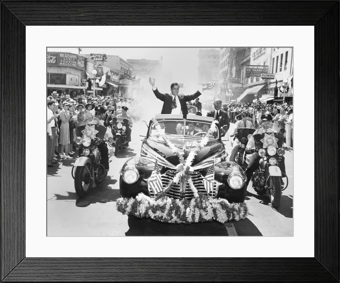 Framed Print : Wendell Willkie accepts the applause of the crowd in Phoenix, Arizona, on Sept. 19, 1940. His flag and flower bedecked convertible is flanked by motorcycle police
