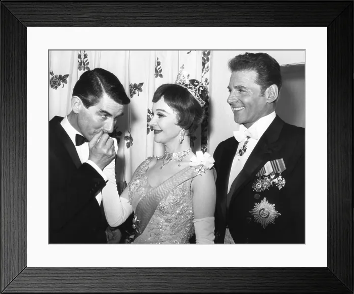 Framed Print : Director Peter Glenville kisses hand of Vivien Leigh's hand with actor Jean Pierre Aumont at right. March 18, 1963