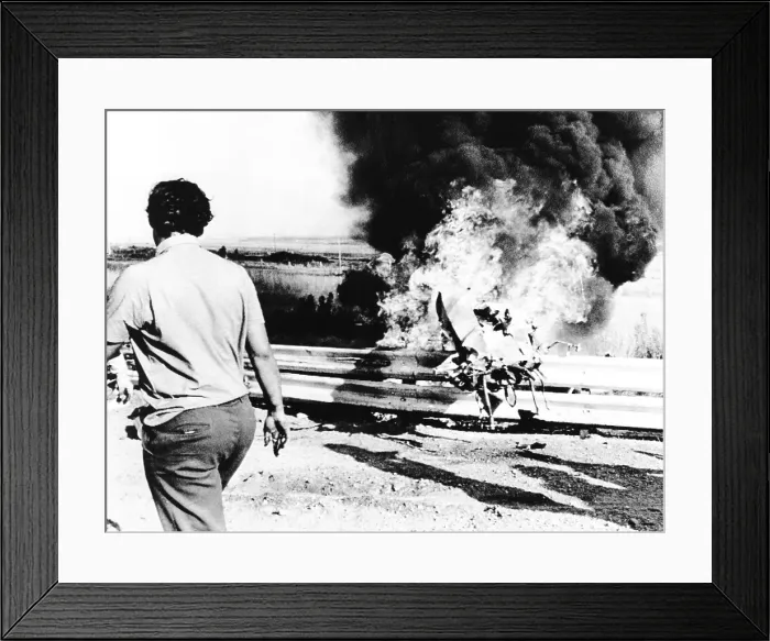 Framed Print : Burning wreckage of Peter Revson's race car jammed against the race track guard rail. The fatal crash occurred during a practice session for the South African Grand Prix Framed Print : Burning wreckage of Peter Revson's race car jammed against the race track guard rail. The fatal crash occurred during a practice session for the South African Grand Prix
