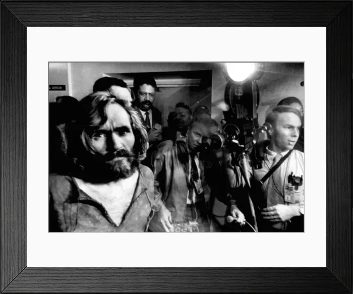 Framed Print : Charles Manson, the 35-year-old cult leader, is escorted through a crowd of newsmen as he arrives at the Los Angeles city jail after a trip from Independence, CA Framed Print : Charles Manson, the 35-year-old cult leader, is escorted through a crowd of newsmen as he arrives at the Los Angeles city jail after a trip from Independence, CA