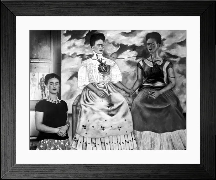Framed Print : Frida Kahlo shown with her painting Me Twice. The painting shows Kahlo as a 19th century lady linked by an artery to herself dressed as an Indian