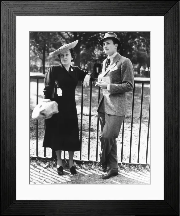Framed Print : Gloria Swanson, attended the races at Belmont Park, NYC, Long Island on Sept. 24, 1938. The 39 year old actress was escorted by an handsome young man, Ira Richards, Jr