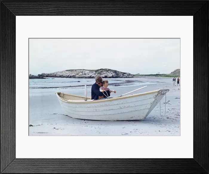 Framed Print : President John Kennedy and John Jr. play in a beached rowboat at Newport, Rhode Island. 1962