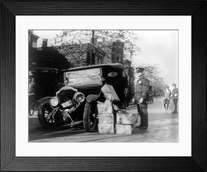 Framed Print : Prohibition, a policeman standing alongside a wrecked car and cases of moonshine, November 16, 1922