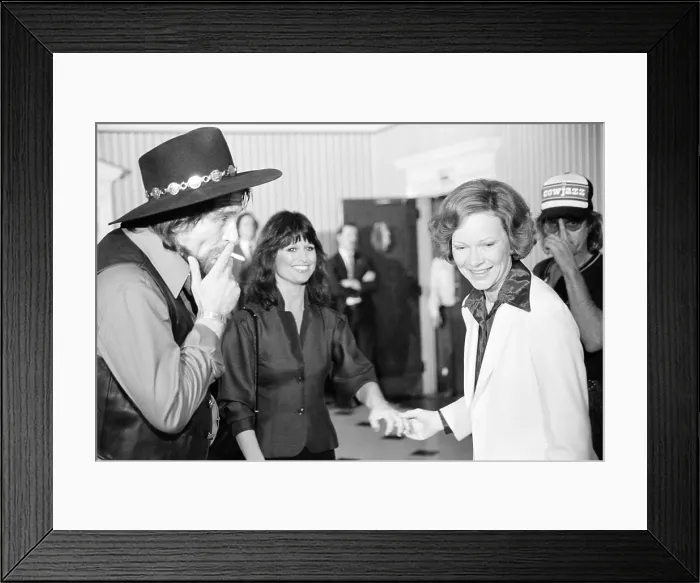 Framed Print : First Lady Rosalynn Carter with Waylon Jennings, smoking a cigarette, and Jesse Colter at a reception preceding a concert to benefit the Carter-Mondale campaign, April 23, 1980