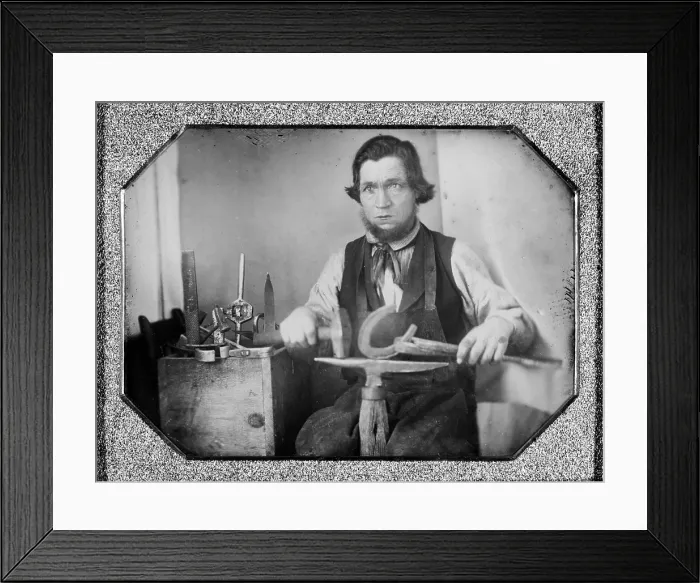 Framed Print : Occupational portrait of a blacksmith, working on a horseshoe at an anvil, other tools to his side. quarter plate daguerreotype, 1840-1860 Framed Print : Occupational portrait of a blacksmith, working on a horseshoe at an anvil, other tools to his side. quarter plate daguerreotype, 1840-1860