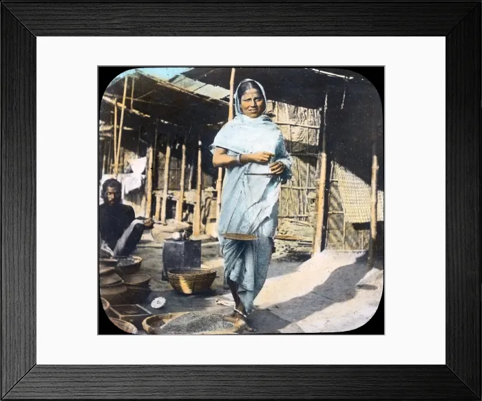 Framed Print : India, a young woman street vendor holding measuring scales, hand colored lantern slide, photograph by William Henry Jackson, 1895